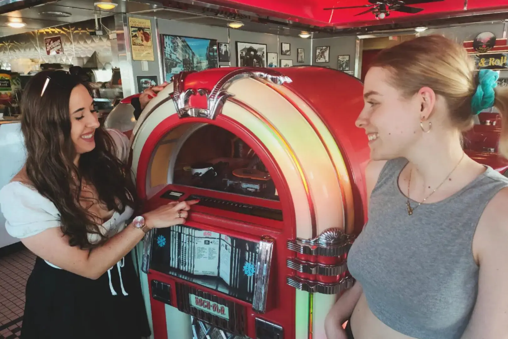 Two people are looking at a jukebox.