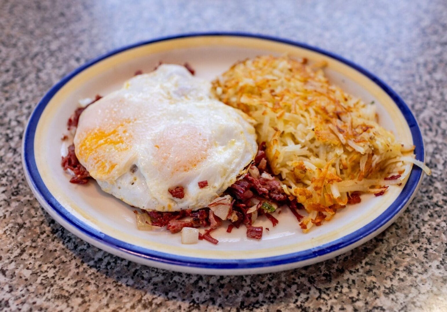A plate of food with eggs and hash browns.